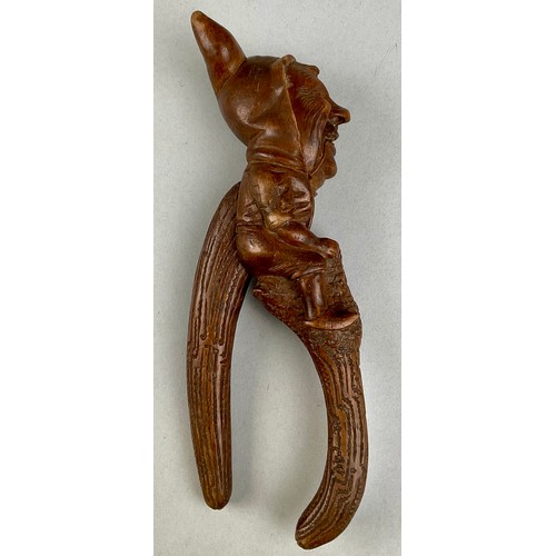 3002 - A Black Forest novelty lever-action nut cracker, carved with a smiling gnome, full-length, 28cm long... 