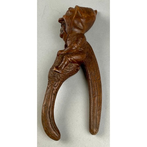 3002 - A Black Forest novelty lever-action nut cracker, carved with a smiling gnome, full-length, 28cm long... 