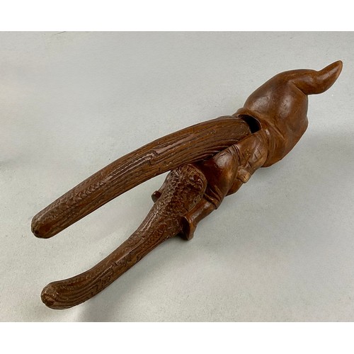 3002 - A Black Forest novelty lever-action nut cracker, carved with a smiling gnome, full-length, 28cm long... 