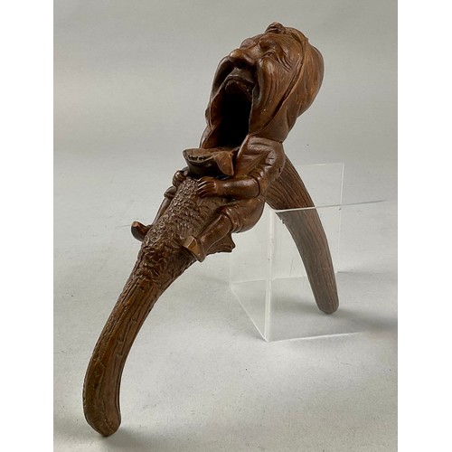 3002 - A Black Forest novelty lever-action nut cracker, carved with a smiling gnome, full-length, 28cm long... 