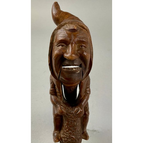 3002 - A Black Forest novelty lever-action nut cracker, carved with a smiling gnome, full-length, 28cm long... 