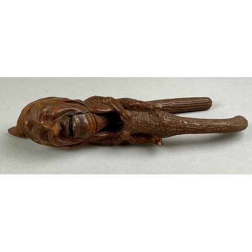 3002 - A Black Forest novelty lever-action nut cracker, carved with a smiling gnome, full-length, 28cm long... 