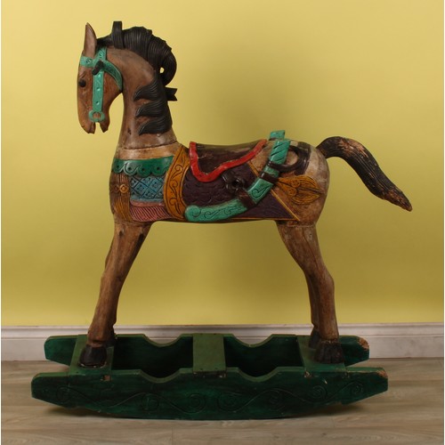 16 - Juvenalia - a carved rocking horse, painted in polychrome, 115cm high, 104cm long overall