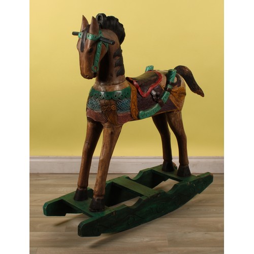16 - Juvenalia - a carved rocking horse, painted in polychrome, 115cm high, 104cm long overall