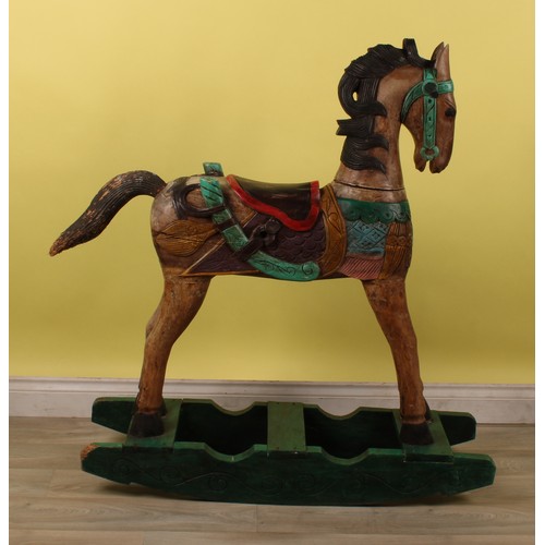 16 - Juvenalia - a carved rocking horse, painted in polychrome, 115cm high, 104cm long overall