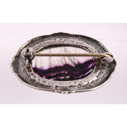 17 - An Elizabeth II blue John and silver mounted oval brooch, cast with foliate scrolls, 3.5cm wide, She... 