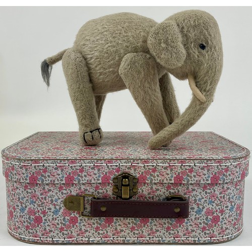 3037 - An early 20th century burlap plush jointed elephant, probably Steiff, boot button eyes, 15.5cm high,... 