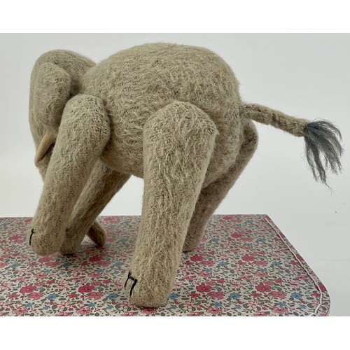 3037 - An early 20th century burlap plush jointed elephant, probably Steiff, boot button eyes, 15.5cm high,... 