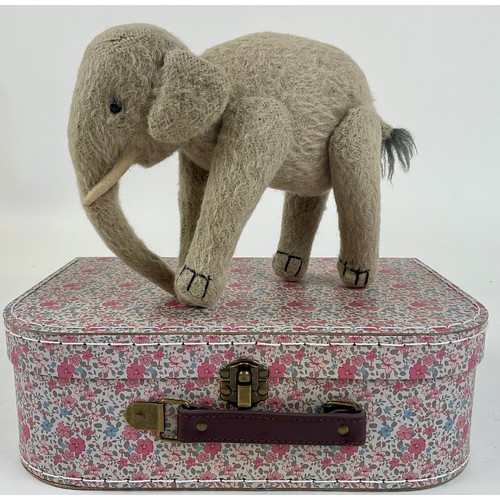 3037 - An early 20th century burlap plush jointed elephant, probably Steiff, boot button eyes, 15.5cm high,... 