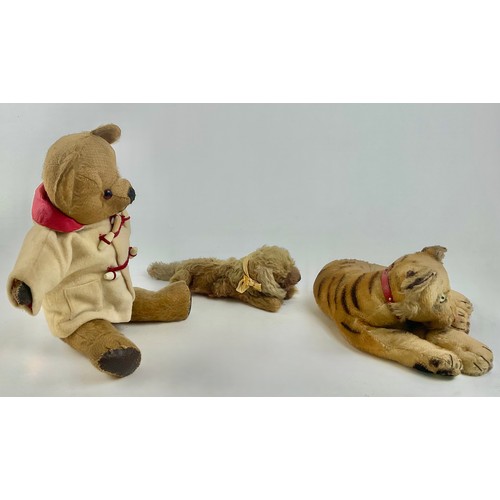 3050 - An early 20th century Steiff mohair plush lying tiger, with green cats eyes, stitched nose and paws,... 