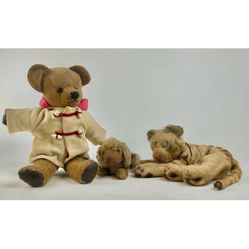 3050 - An early 20th century Steiff mohair plush lying tiger, with green cats eyes, stitched nose and paws,... 