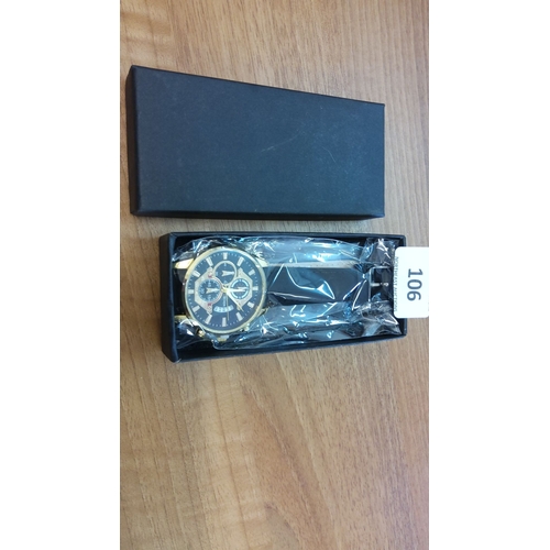 106 - Boxed chronograph wristwatch with a black dial, gold-tone indices, and a black leather strap.