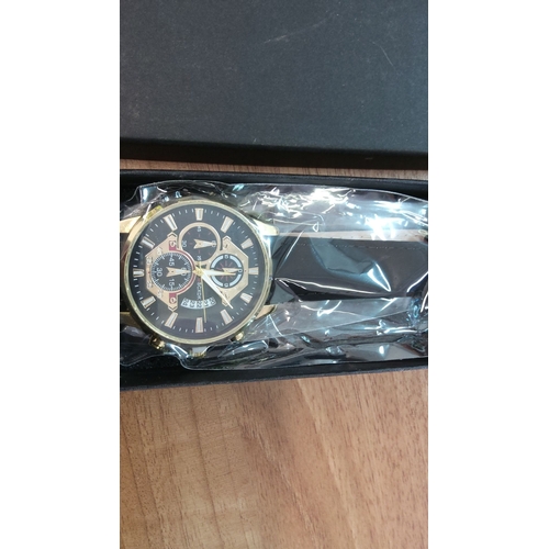 106 - Boxed chronograph wristwatch with a black dial, gold-tone indices, and a black leather strap.