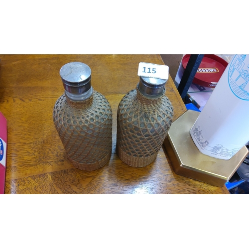 115 - Pair of vintage wicker-covered glass bottles with metal lids.