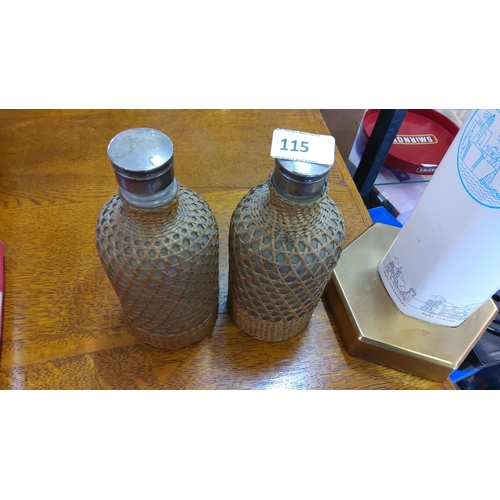 115 - Pair of vintage wicker-covered glass bottles with metal lids.