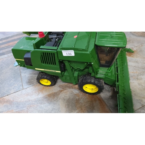 136 - John Deere green toy combine harvester model with detailed moving parts, characteristic yellow wheel... 