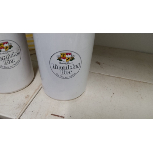 141 - Pair of Hiemickel Bier ceramic beer steins featuring a white finish and the brewery logo on the fron... 