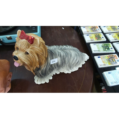 234 - Painted ceramic figurine of a Yorkshire Terrier wearing a red bow. Charmingly detailed.