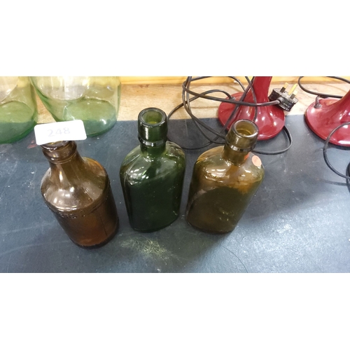 248 - Set of three antique glass bottles in various shades of green and brown. The bottles come in round a... 