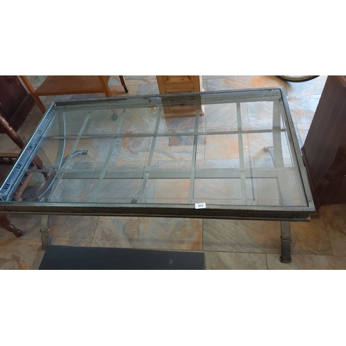 303 - Glass-top coffee table with metal frame and grid design. Rectangular shape.