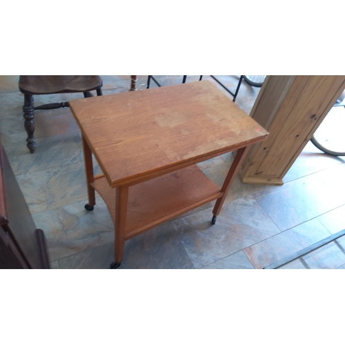 329 - Convertible oak games table with green felt surface, lower storage shelf, and rolling casters.