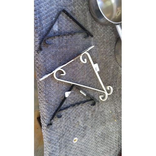 346 - Set of three wrought iron wall brackets, two in black and one in white.