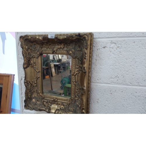 394 - Ornate antique mirror with an elaborately carved, gilt wooden frame. The design exhibits floral and ... 