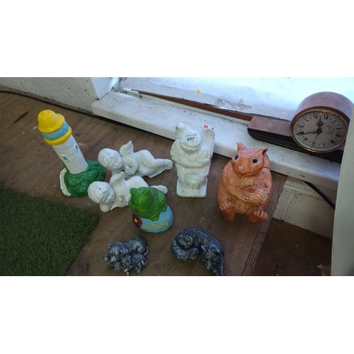 397 - Eight concrete garden ornaments including cherubs, a lighthouse, a frog, a squirrel, and a vintage-s... 