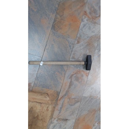 401 - Heavy-duty sledgehammer with wooden handle and metal head. Length: approximately 36 inches.