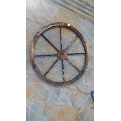 412 - Antique wooden wagon wheel with eight spokes, rustic design. Diameter approximately 32 inches.