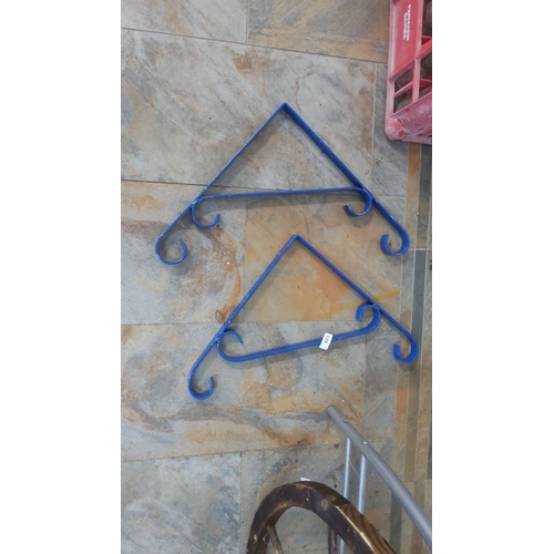 421 - Pair of blue metal wall brackets with scroll design.