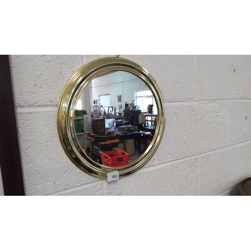 431 - Gold-colored round wall mirror with reflective glass surface.