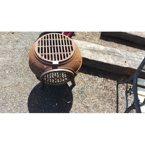 453 - Rustic cast iron fire pit with mesh sides and grated top. Features ornate legs and a circular design... 