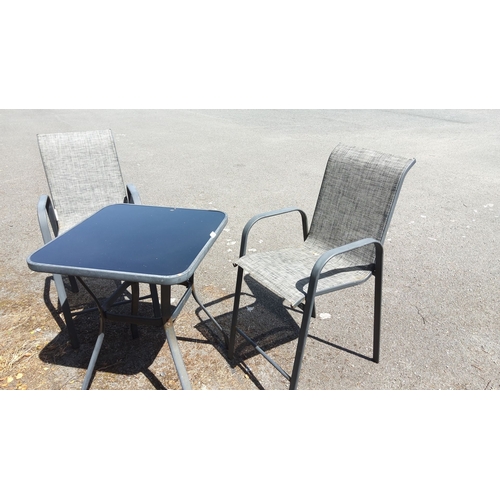 458 - Outdoor patio set with black glass-top table and two gray mesh sling chairs featuring metal frames.