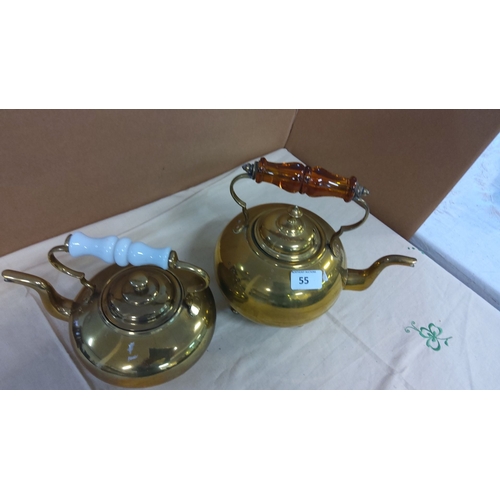 55 - Pair of vintage brass kettles. One has a white porcelain handle, the other has an amber glass handle... 