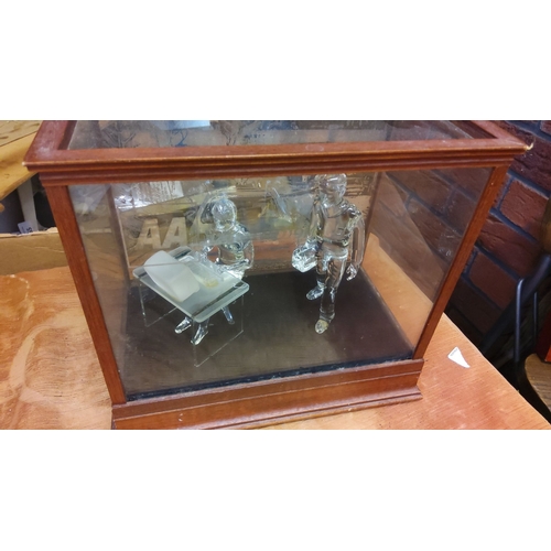 91 - Wooden display case with glass figurines. The case is crafted from wood with beveled edges and trans... 