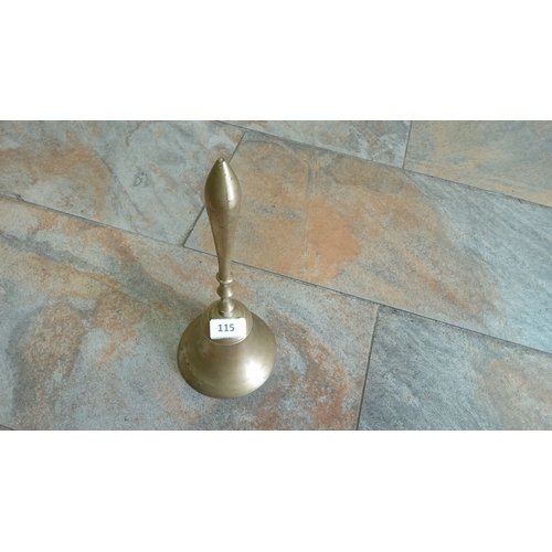 115 - Antique brass hand bell with a polished finish and elongated handle design. Features a circular base... 
