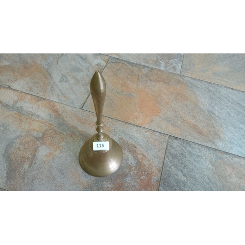 115 - Antique brass hand bell with a polished finish and elongated handle design. Features a circular base... 
