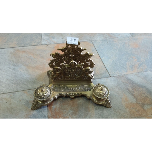 118 - Late Victorian brass inkstand with two inkwells and ornate detailing, featuring cherubs and scrollin... 