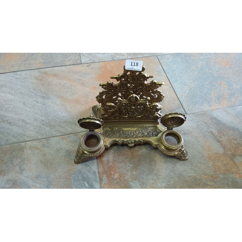 118 - Late Victorian brass inkstand with two inkwells and ornate detailing, featuring cherubs and scrollin... 