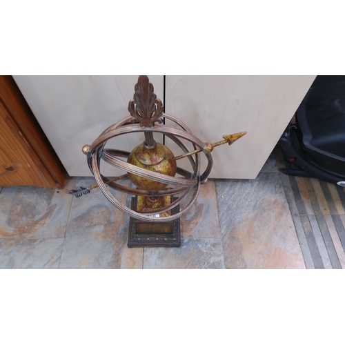 120 - Antique-style brass armillary sphere with decorative finial and pedestal base.