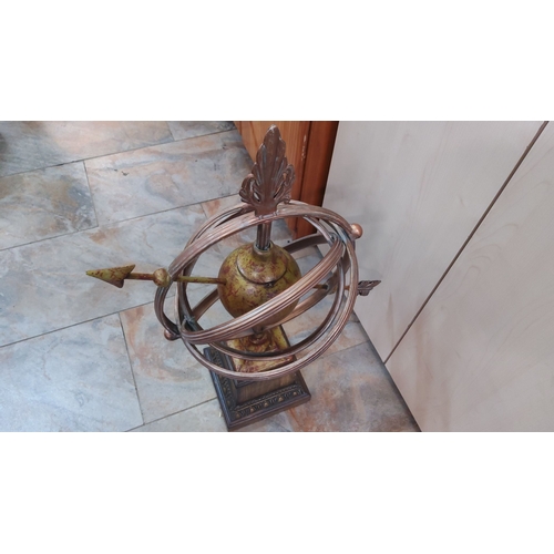 120 - Antique-style brass armillary sphere with decorative finial and pedestal base.