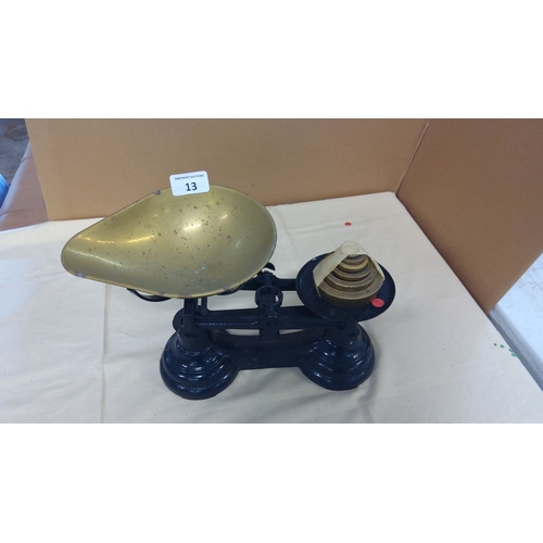 13 - Antique brass balance scale with nested weights and cast iron base. Features a large, curved brass p... 