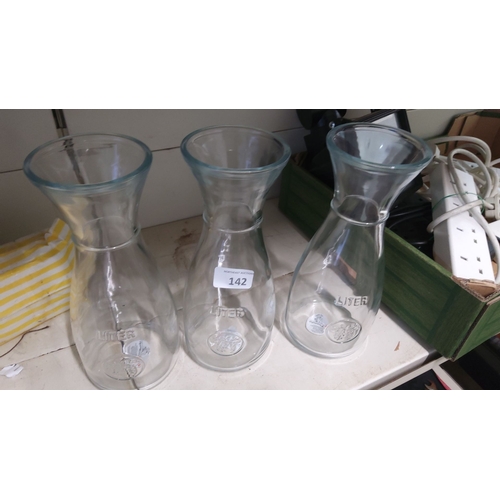 142 - Set of three clear glass carafes, each with 