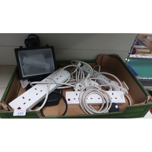 143 - Box containing assorted electrical extension cords and a floodlight.