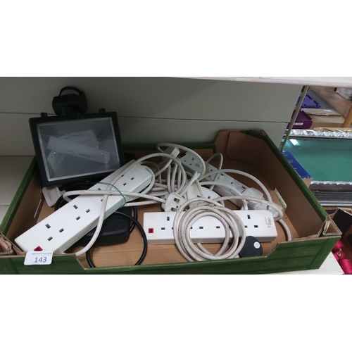 143 - Box containing assorted electrical extension cords and a floodlight.