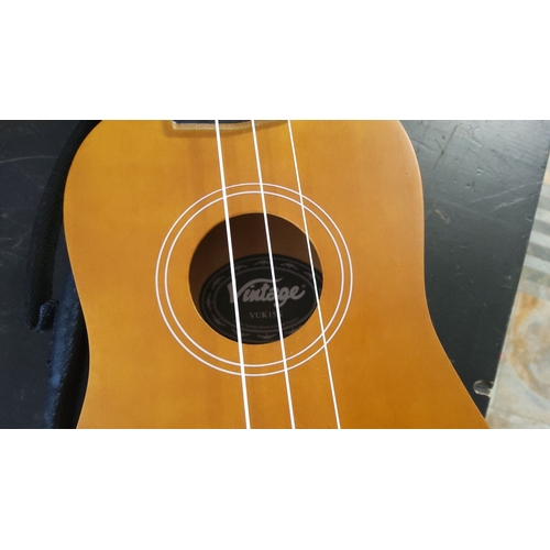 152 - Vintage VUK15 ukulele, featuring a natural wood finish with a compact design, supported by white nyl... 