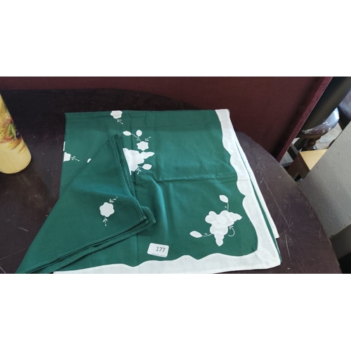 177 - Green floral embroidered table linens, with a white border and floral design. Includes matching napk... 