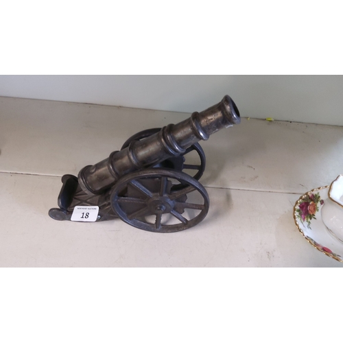 18 - Vintage cast iron model cannon with rolling wheels, detailed craftsmanship.