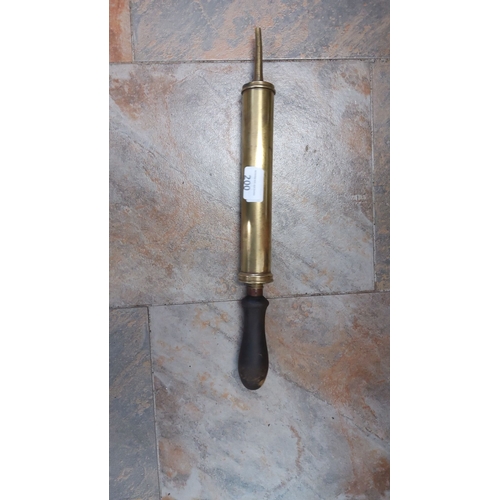 200 - Vintage brass pump with wooden handle. This hand-operated device features a cylindrical brass body a... 